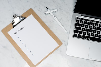 Checklist op een klembord naast een laptop